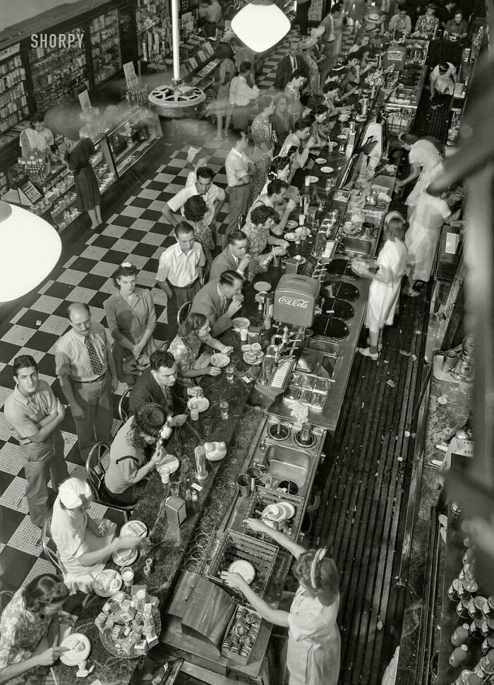 Overhead view of a busy diner with many customers and staff, capturing historical photos of daily life.