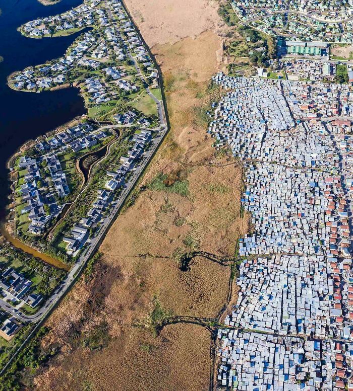 Aerial view of urban hell showing stark contrast between luxury homes and dense shantytown