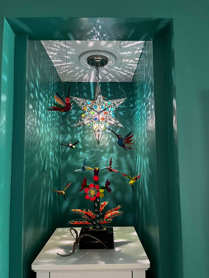 A vibrant display of colorful bird sculptures and a star-shaped light creating intricate patterns, perfect for home decor projects.