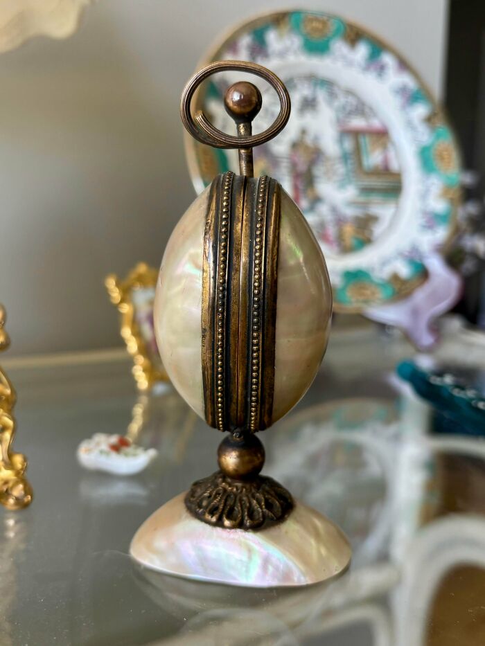 A remarkable antique decorative item, possibly an egg holder, with mother-of-pearl and bronze accents.