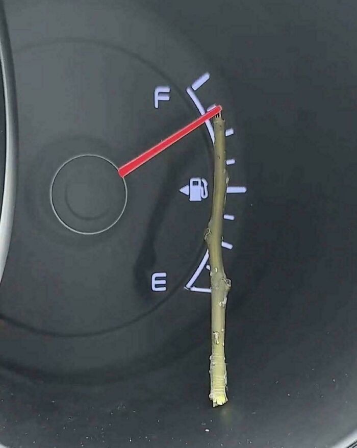 A peculiar stick is placed on a car's fuel gauge, indicating a full tank. People spotted this peculiar thing in real life.
