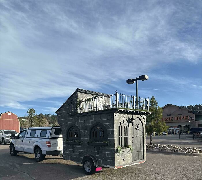 Unique small home trailer with gothic stone design parked in commercial area