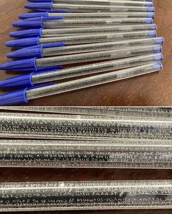 A close-up, interesting photo revealing tiny, illegible script written inside several clear ballpoint pen barrels.