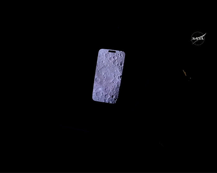 A smartphone screen displaying a detailed image of the moon's surface against a dark background, an interesting photo.
