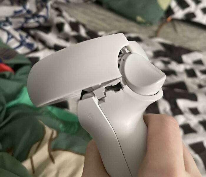 Close-up of a broken white gaming controller held in hand, showing the true colors of friends in moments of frustration.