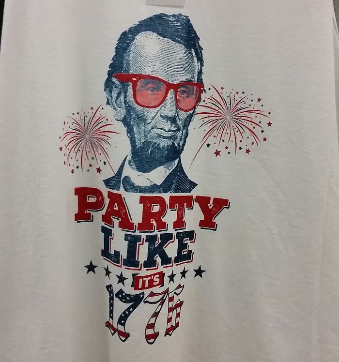 T-shirt with a funny design featuring Abraham Lincoln wearing red glasses and text party like 1776 with fireworks.