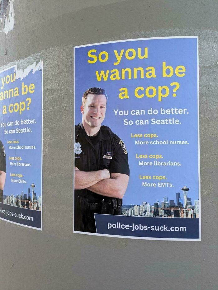 Poster on wall showing a police officer with text advocating less cops and more community support in life in America.