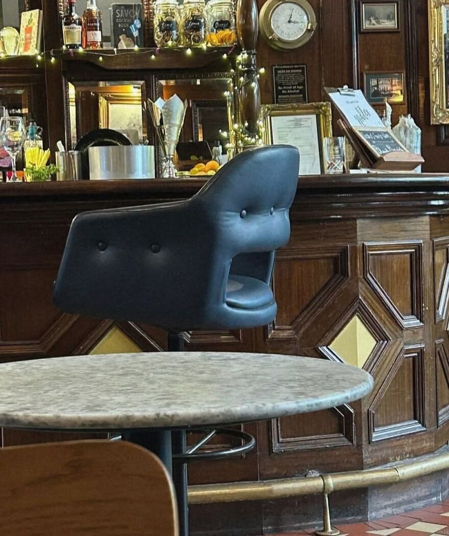 Bar stool resembling a face with mouth open at a vintage wooden bar, showcasing a classic pareidolia example in a cozy setting.