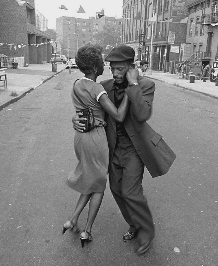 Couple dancing closely on a city street in a rare and fascinating historic photo capturing life in a different era.