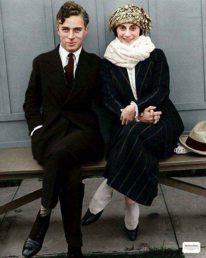 Young couple dressed in early 20th-century attire sitting on a bench, a rare and fascinating historic photo capturing the era.