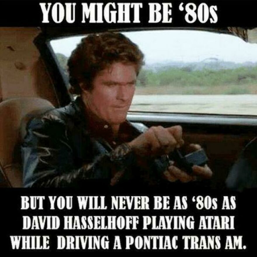 Man in leather jacket playing Atari while driving a Pontiac Trans Am, illustrating 80s lifestyle moments that no longer exist.