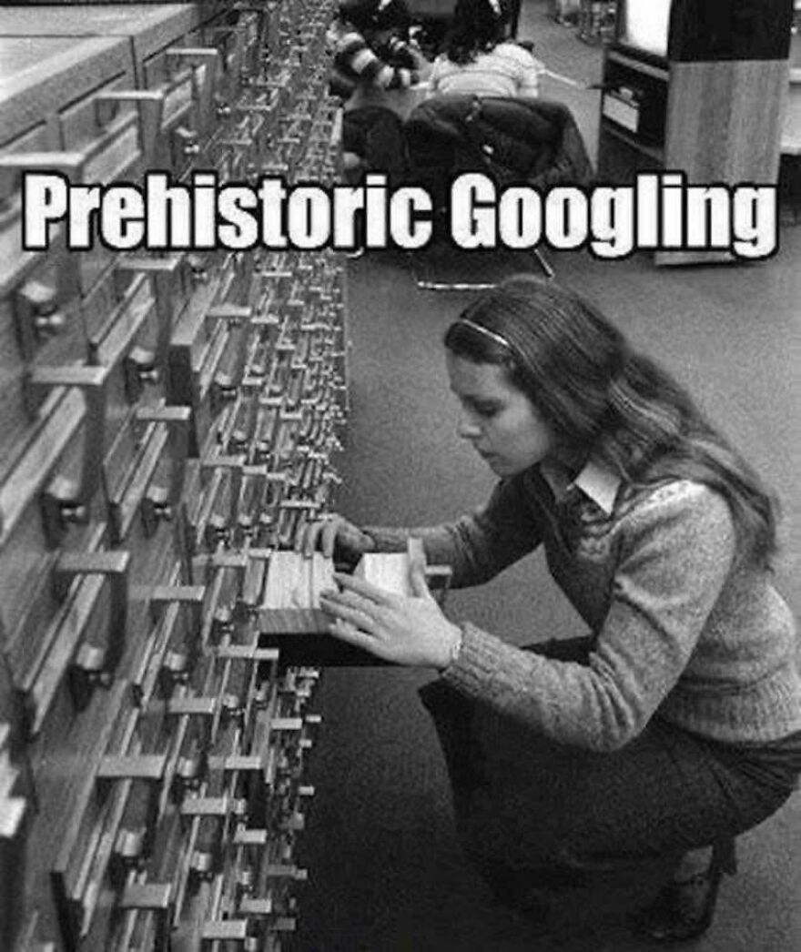 Woman using a card catalog in a library, illustrating parts of our lives from the 80s that don’t exist anymore.
