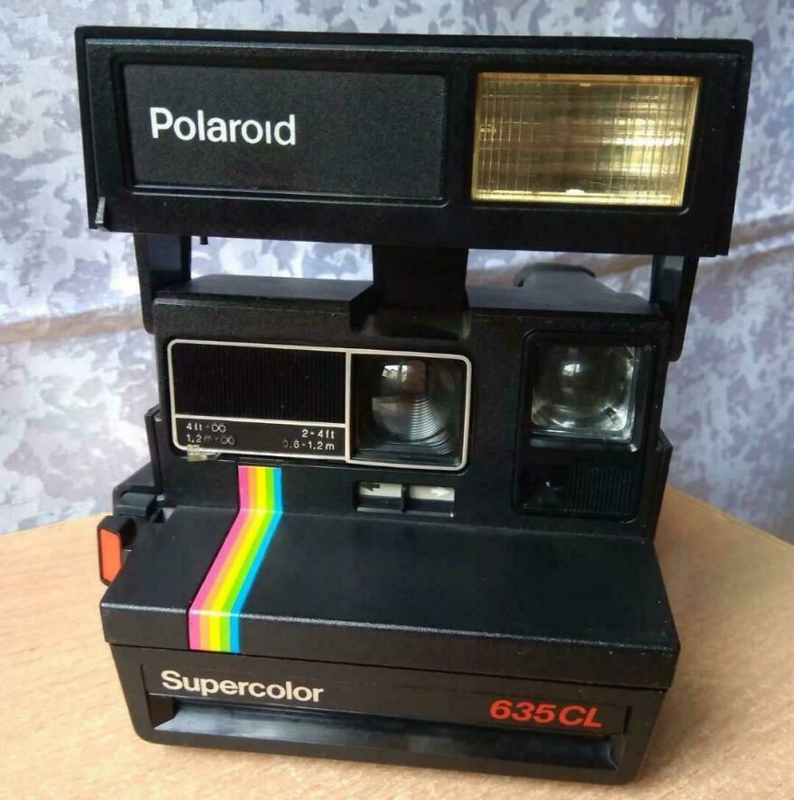 Vintage Polaroid Supercolor 635CL camera with rainbow stripe, representing 80s technology no longer common in everyday life.