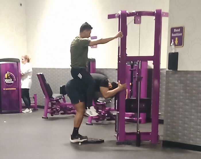 Two gym-goers attempt a risky workout pose, a Darwin Award contender moment at the gym with unusual exercise methods.