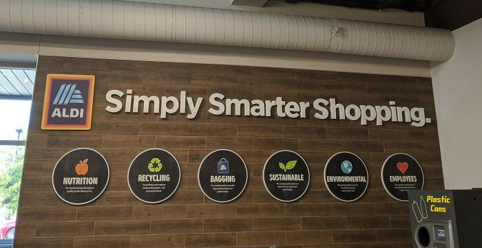 Aldi store sign: Simply Smarter Shopping, with icons for Nutrition, Recycling, Bagging, Sustainable, Environmental, and Employees. No upside-down things here.