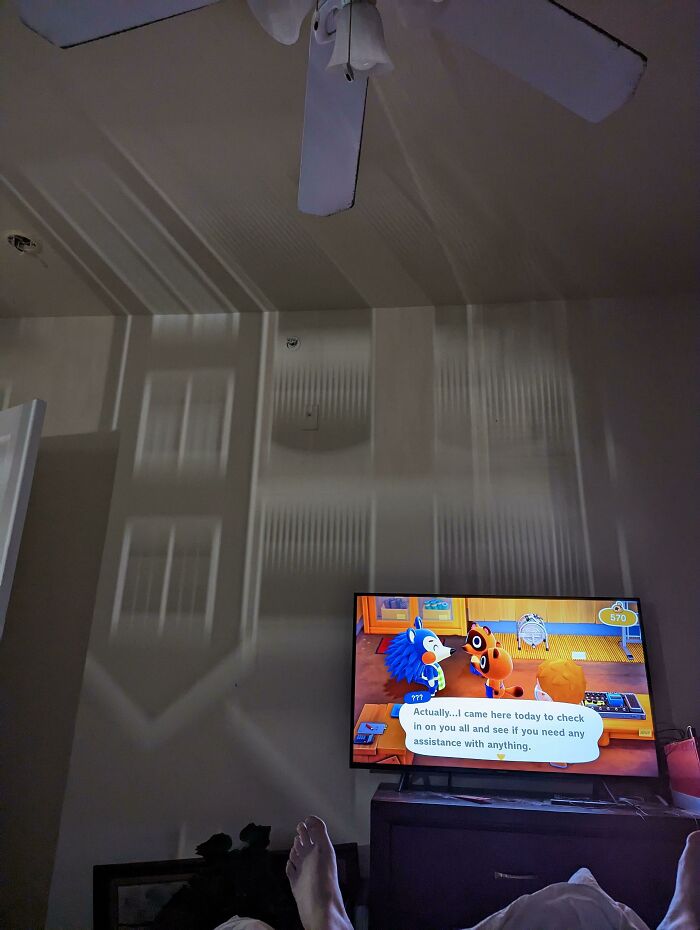 Light from an external window reflects on the ceiling, creating an upside-down appearance of the room on the wall.