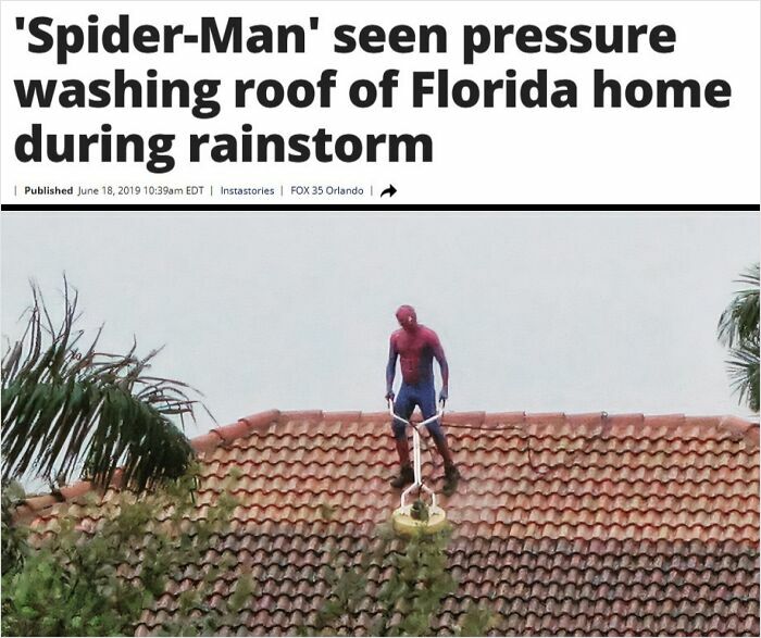 Person dressed as Spider-Man pressure washing roof of Florida home during heavy rain with visible wet and dry tiles.