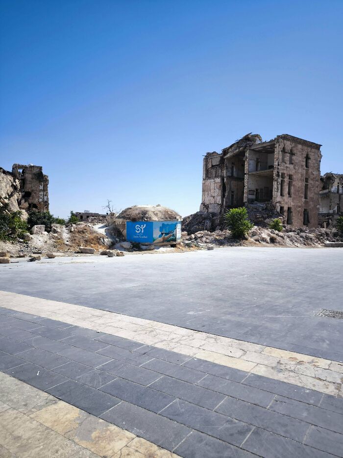 Urban hell with ruined buildings and empty cracked pavement under clear blue sky