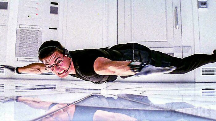 Tom Cruise hanging from the ceiling in a movie scene, illustrating nonsensical movie details.
