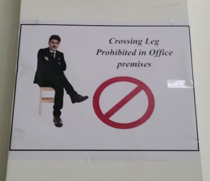 Sign showing a man crossing his leg with text prohibiting leg crossing in office, a confusing and funny sign from There Are Bees collection.