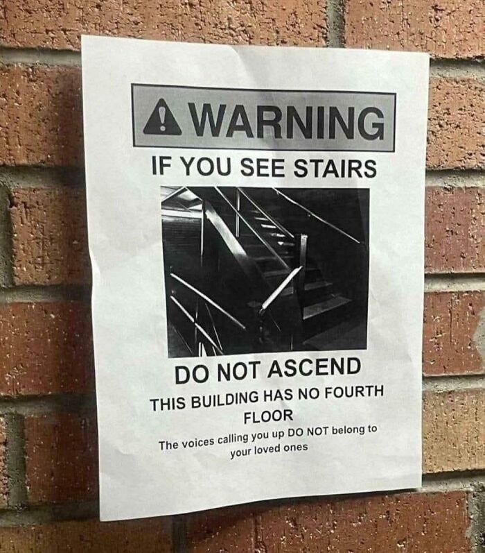 Warning sign on brick wall humorously advising not to ascend stairs in building with no fourth floor confusing funny signs.