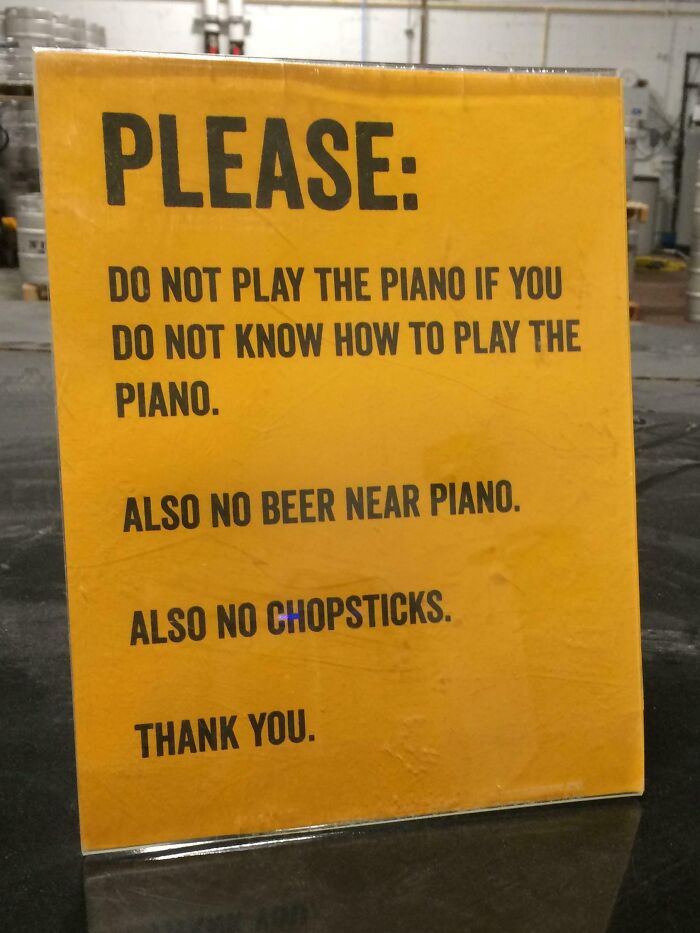 Yellow humorous sign with confusing rules about playing piano, beer, and chopsticks, part of funny confusing signs collection.