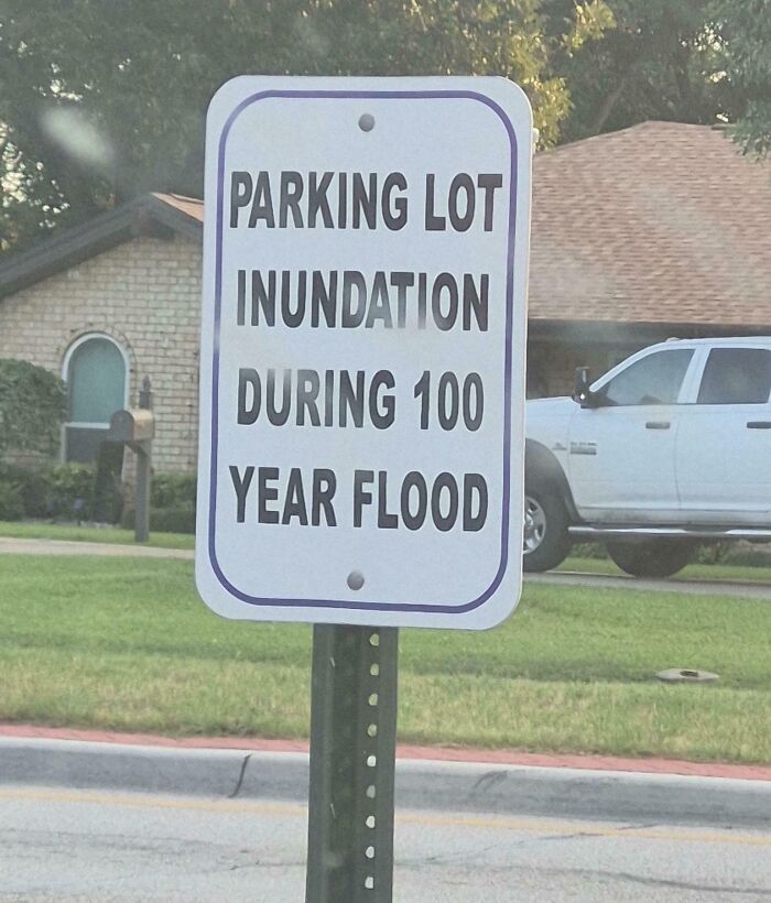 Parking lot inundation sign warning about flooding during a 100 year flood, a confusing and funny sign.