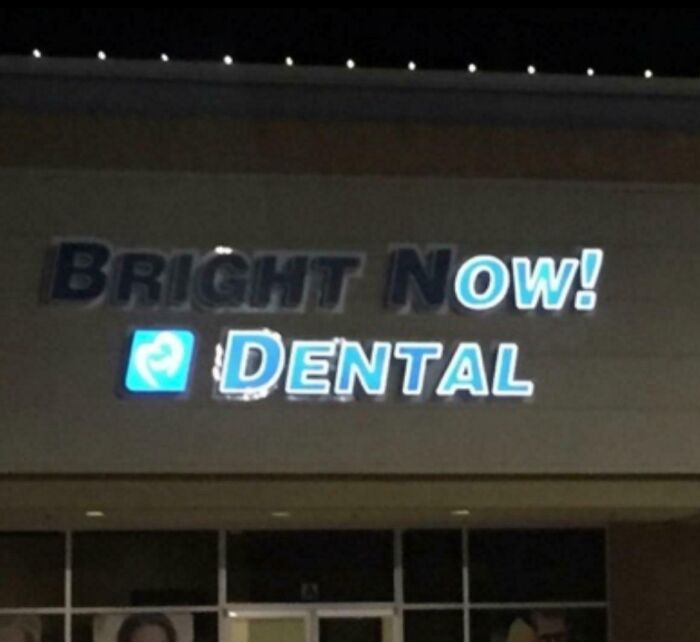 Bright now dental sign lit up oddly at night, creating a confusing and funny visual effect involving bees.