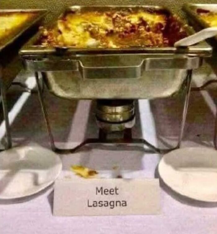 Chafing dish with lasagna and a humorous sign labeled meet lasagna at a buffet table.