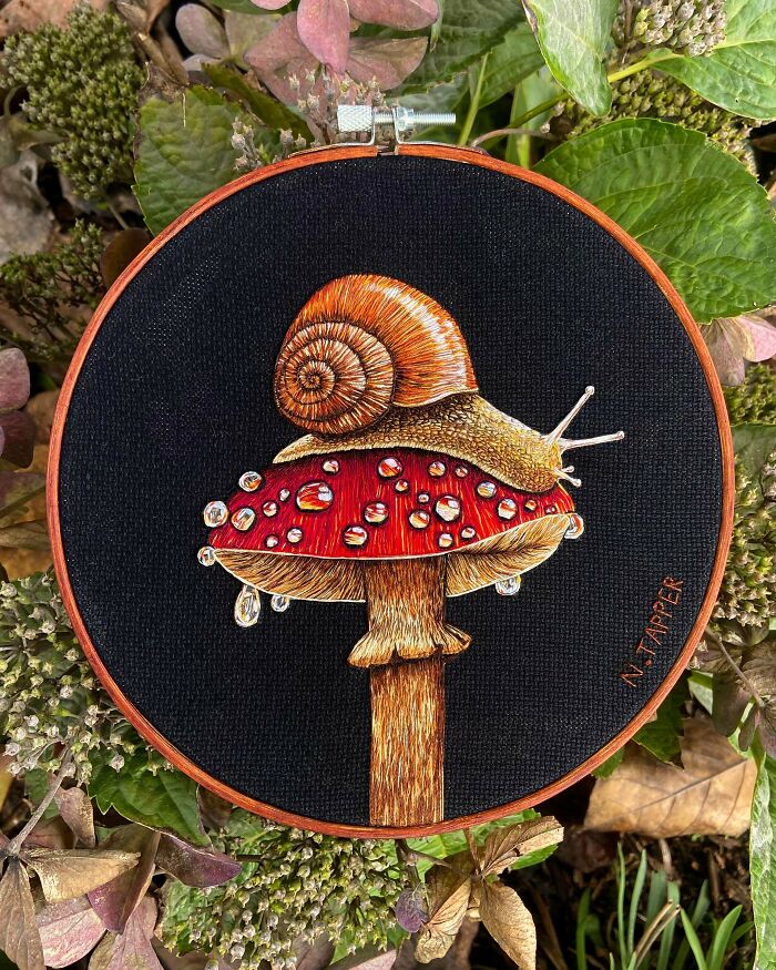 Stunning embroidery creation of a snail on a red mushroom with water droplets, inspiring a new hobby.