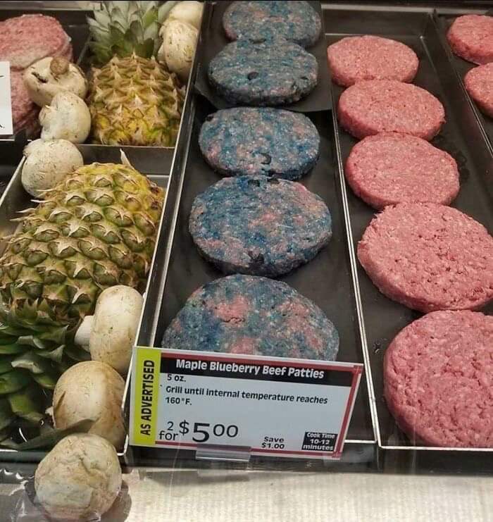Maple Blueberry Beef Patties display, a bananasausage food crime, next to raw beef patties, mushrooms, and pineapples in a store.
