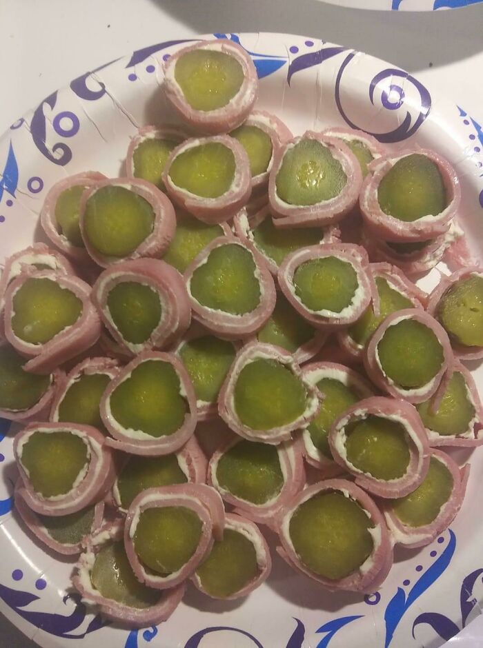 Bananasausage? Pickles wrapped in deli meat with cream cheese, a food crime presented on a paper plate.