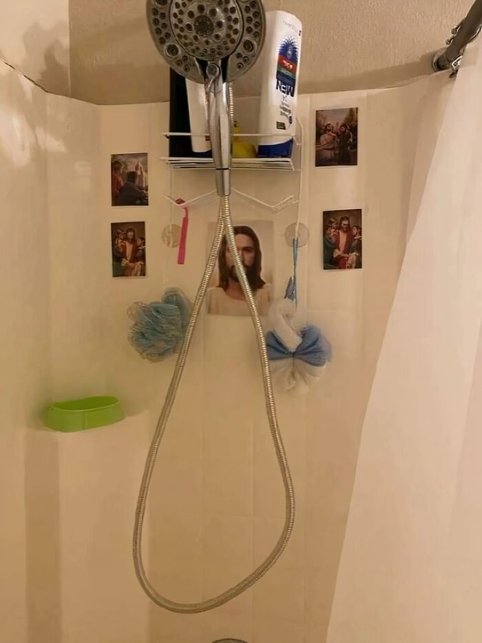 A shower stall decorated with multiple pictures of Jesus, revealing cringey parents' quirky decor style.