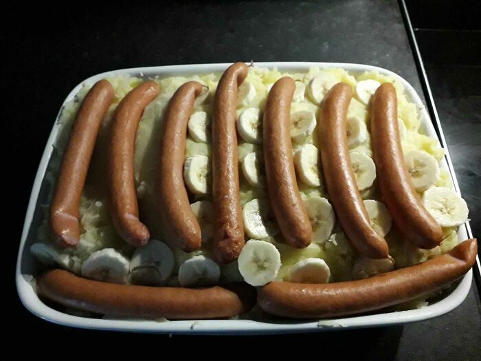 A casserole dish filled with bananasausage and mashed potatoes, a truly questionable food crime.