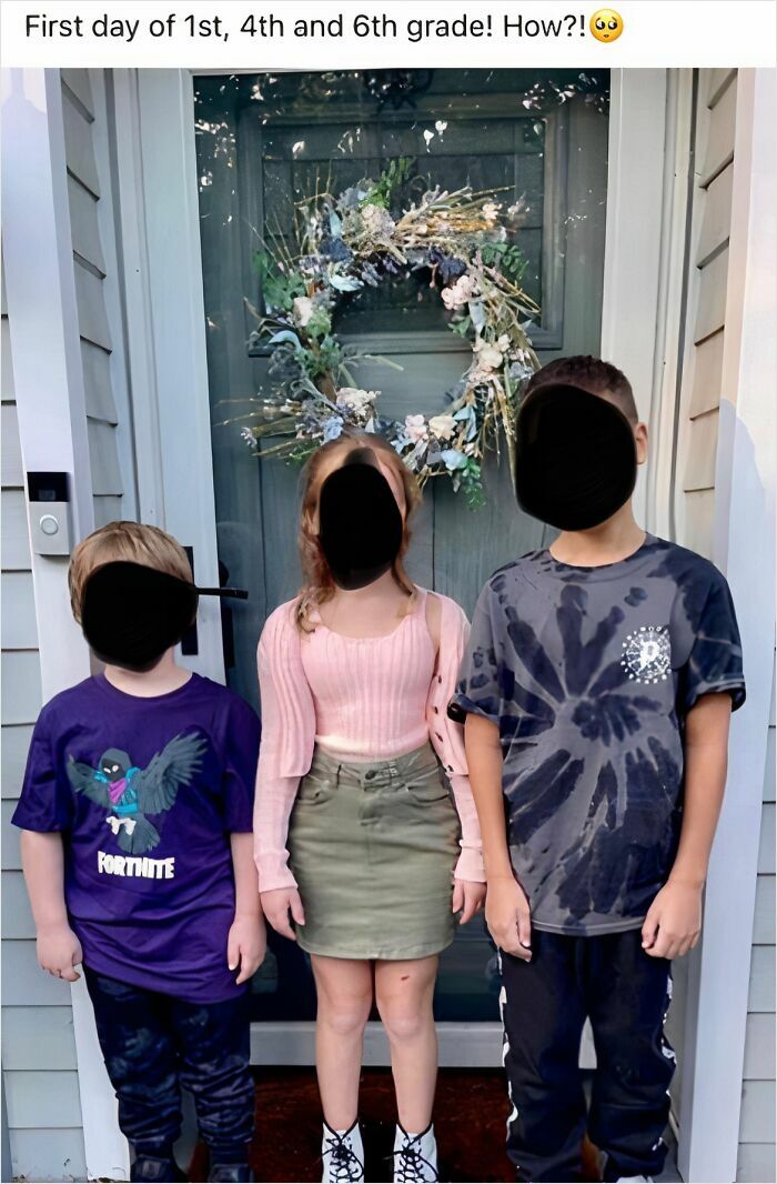 Three kids on their first day of school, posing outside a door with a wreath. Cringey parents capture the moment.