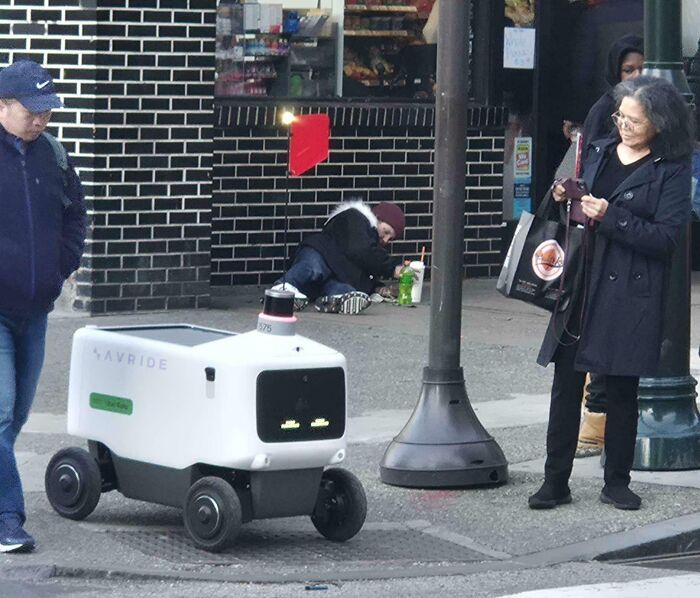 Autonomous delivery robot navigating a busy urban sidewalk, illustrating dystopian technology in the United States.