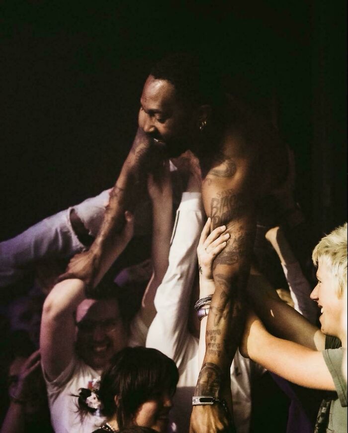 An accidental Renaissance shot of a musician crowd-surfing during a passionate live concert performance