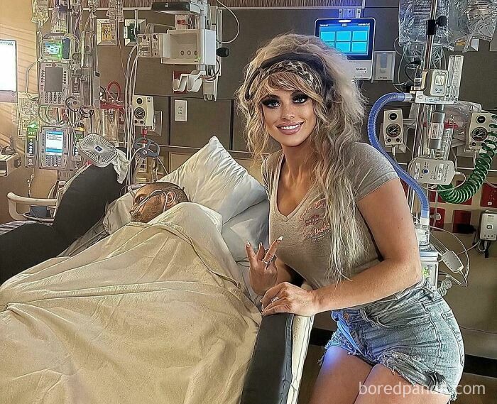 Woman with edited face posing beside patient in hospital bed surrounded by medical equipment in Instagram edits.