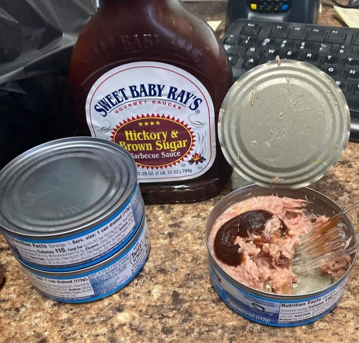 Bananasausage: Tuna from a can, smothered in BBQ sauce, a definite food crime. A plastic fork rests inside.