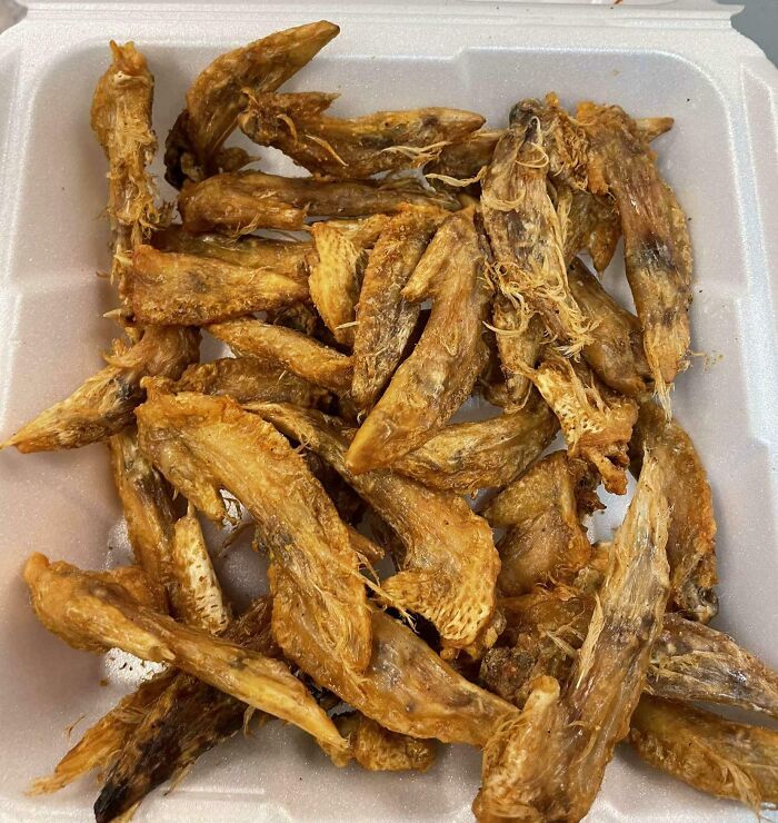 A container of oddly shaped, possibly deep-fried Bananasausage or food crimes that resemble chicken wings.