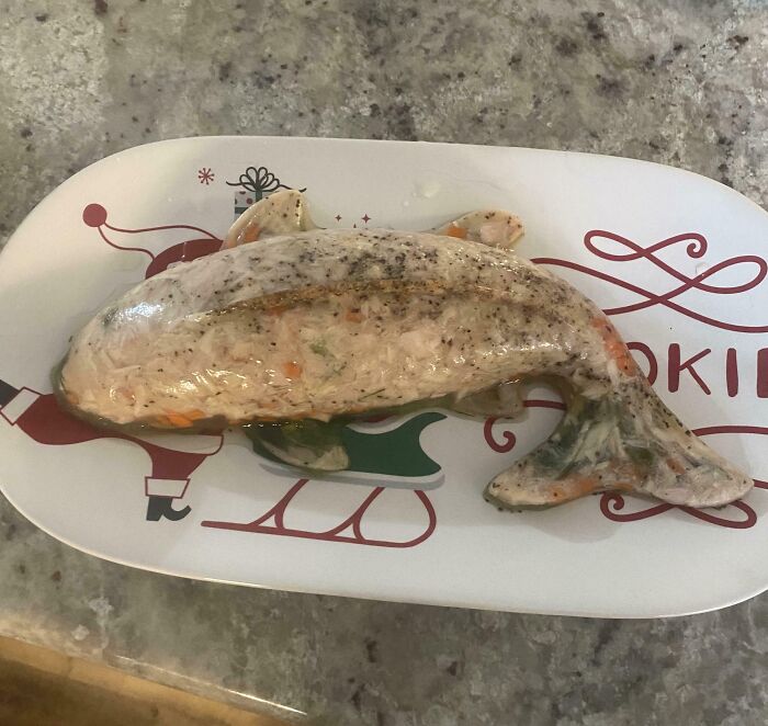 A fish-shaped aspic on a festive plate with Santa and a sleigh, a Bananasausage food crime.