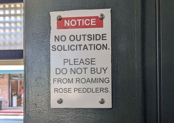 A notice sign reading "NO OUTSIDE SOLICITATION. PLEASE DO NOT BUY FROM ROAMING ROSE PEDDLERS," an oddly specific rule.