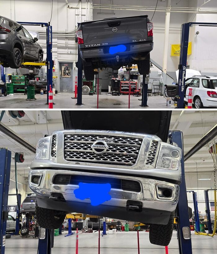 Car mechanics working on a Nissan Titan truck lifted in a garage for inspection and repair.
