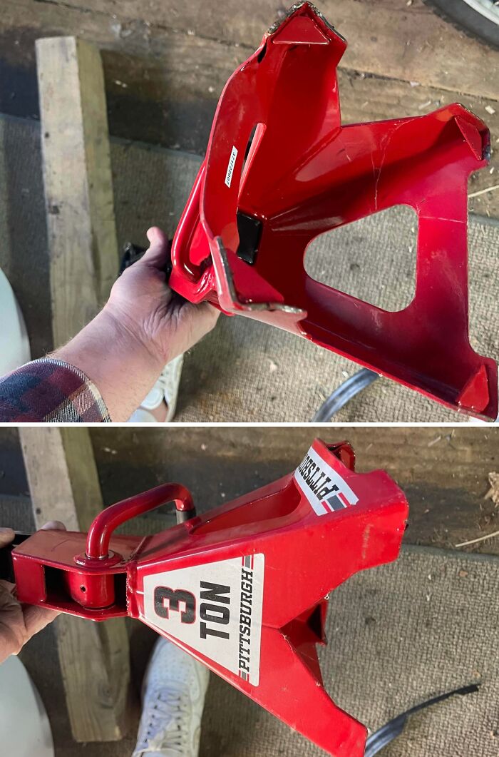 Red 3-ton Pittsburgh jack stand held by a mechanic showing damage for car mechanics to believe the issue.