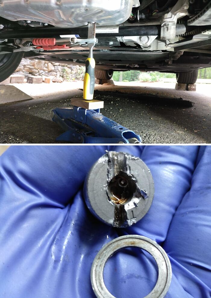 Car mechanics showing damaged car parts and repair tools under a vehicle to prove the issue they faced.