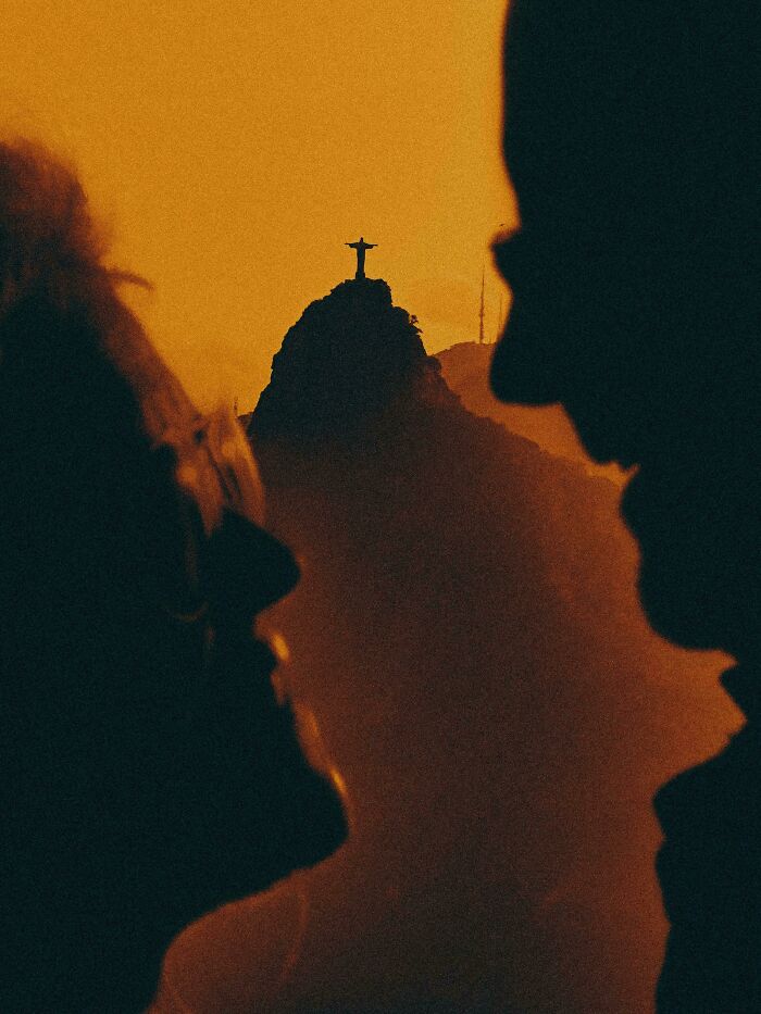 Silhouetted people admire the Christ the Redeemer statue at sunset, offering a gentle reset button for your day.
