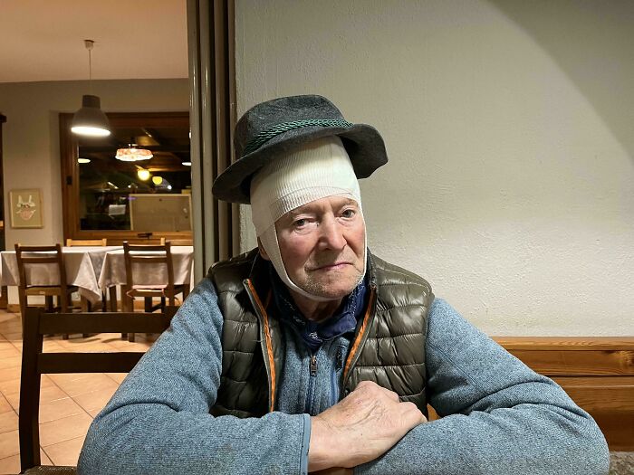 An accidental Renaissance portrait of an elderly man wearing a head bandage and a classic grey hat