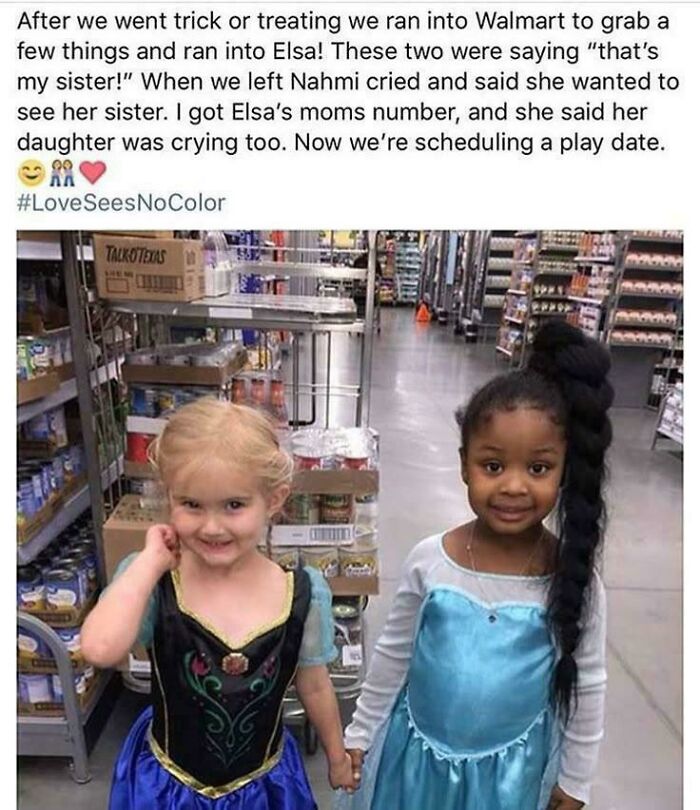 Two young girls dressed as Elsa holding hands in a Walmart aisle, sharing a heartwarming moment of positivity.