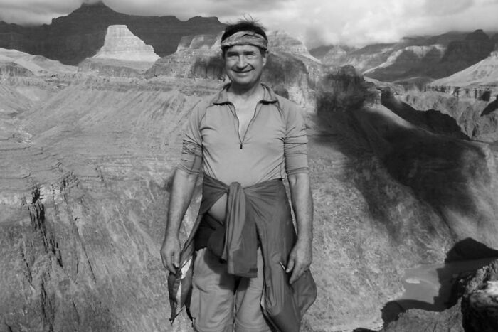 Hiker standing at edge of canyon, surrounded by vast rocky landscape, evoking mysterious events and urban myths.