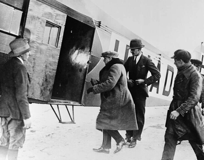 Four men in vintage clothing boarding an old airplane, depicting mysterious events and urban myths from history.